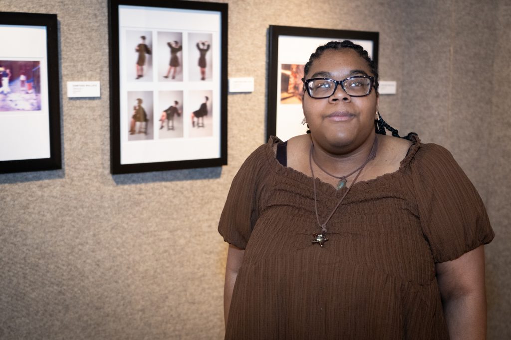 Damiyana Wallace stands in front of her art work