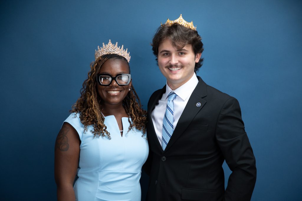 Ciara Guillot and Zander Hall wearing crowns in front of a backdrop
